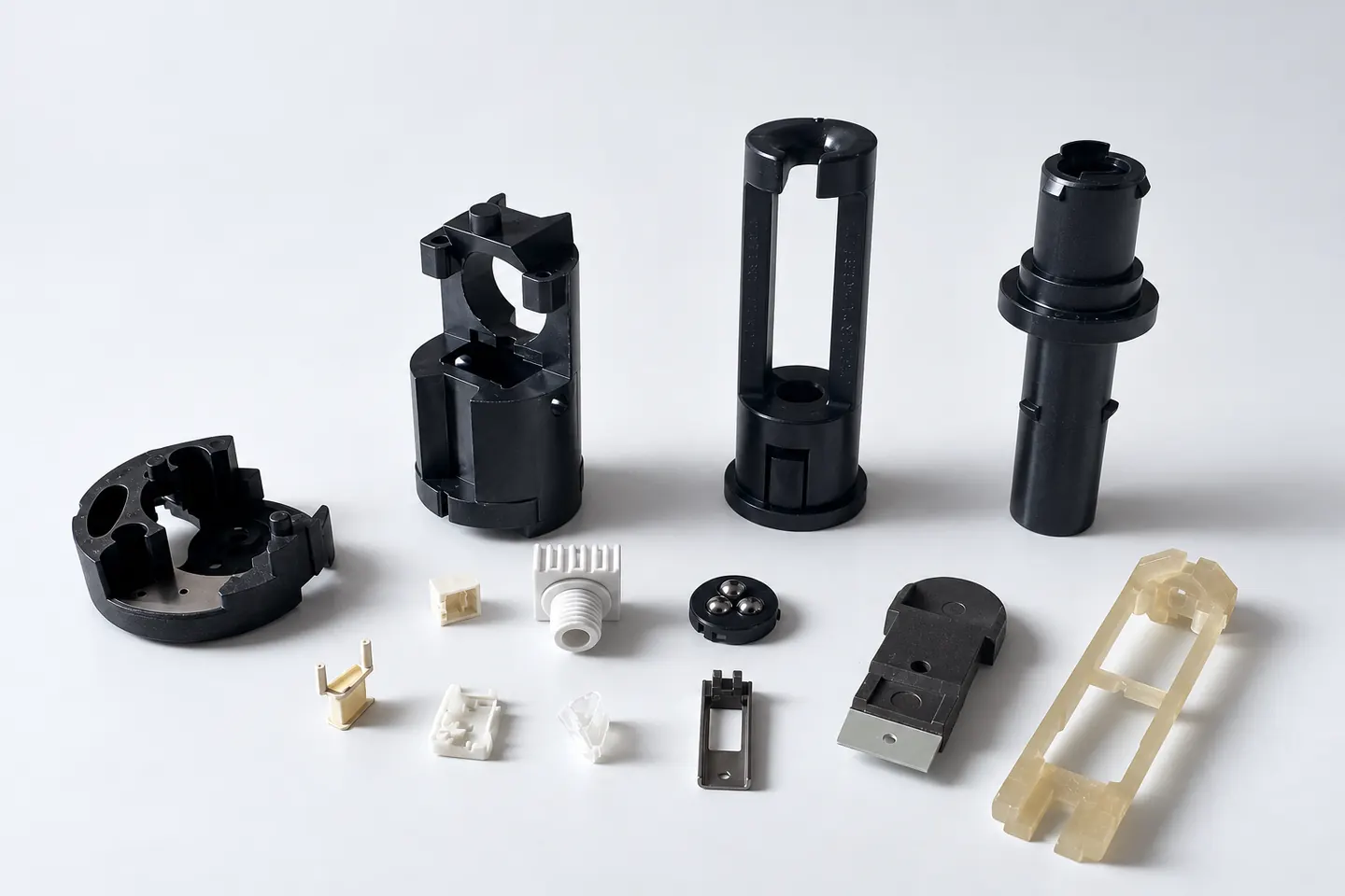 Techno-Synthetic: schwarze Gehäuse, umspritzte Teile und kleine Bauteile für Luftfahrt und Verteidigung, zusammen abgebildet.
